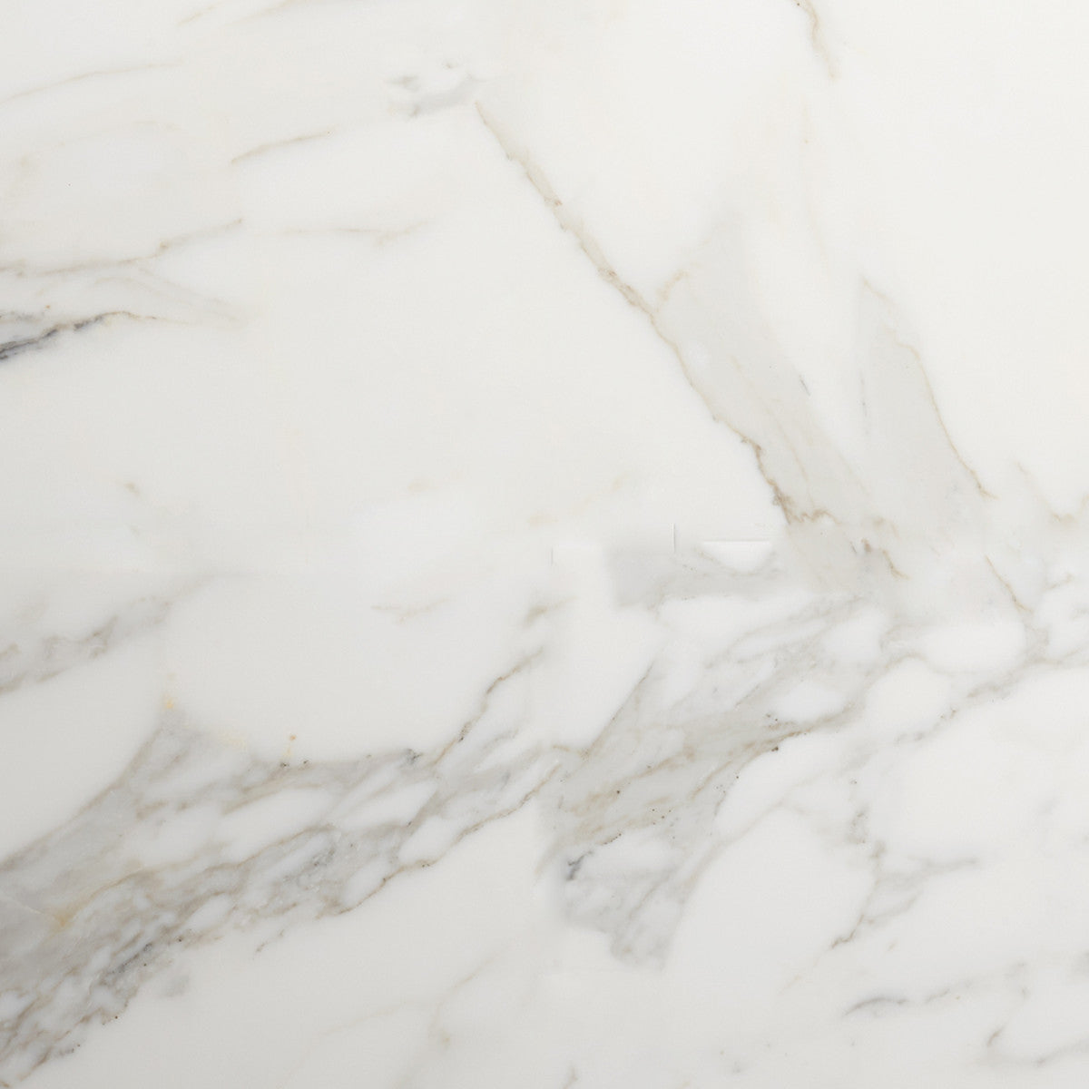White marble surface with light gray and beige veining patterns. The texture is smooth and polished.