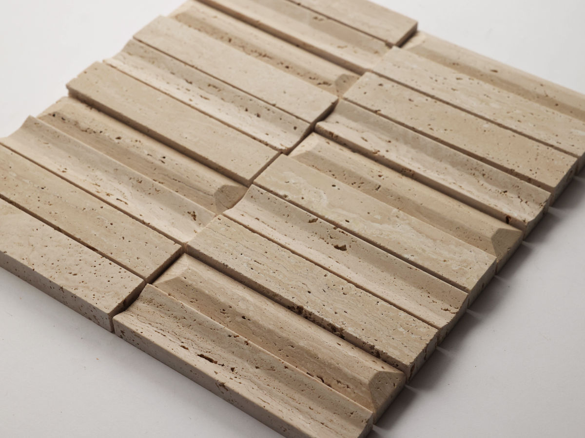 A close-up of a beige travertine tile with a grooved, textured surface and a staggered rectangular pattern.