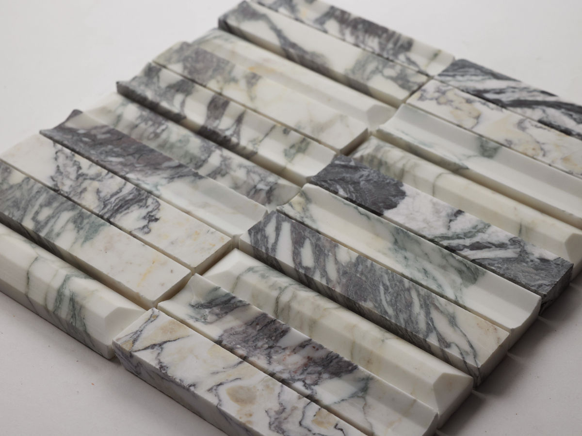 Rectangular marble tiles with varying white, gray, and black veining are arranged in a grid pattern on a white background.