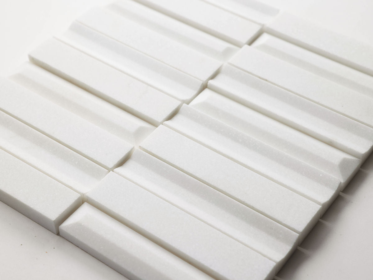 White rectangular tiles arranged in a grid pattern on a flat surface, each tile featuring a raised, ridged design.