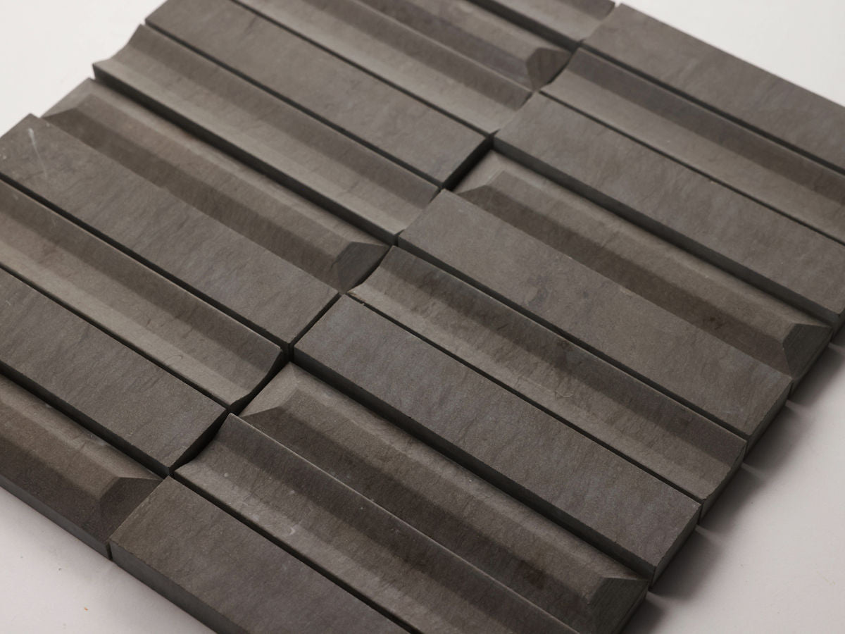 A close-up view of a grid arrangement of rectangular, dark gray tiles with beveled edges on a white background.