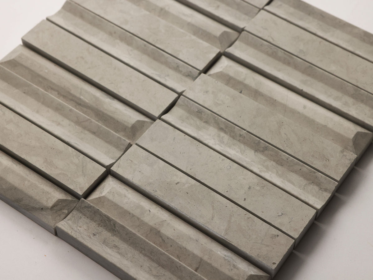 Rectangular grey stone tiles arranged in a geometric, three-dimensional pattern on a flat surface.