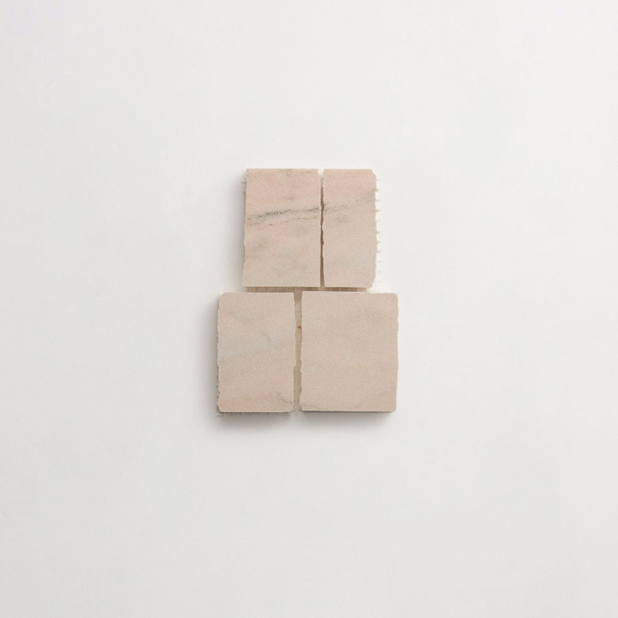 Four square beige tiles arranged in a two-by-two grid on a plain white background. The tiles have subtle natural variations in color and texture.