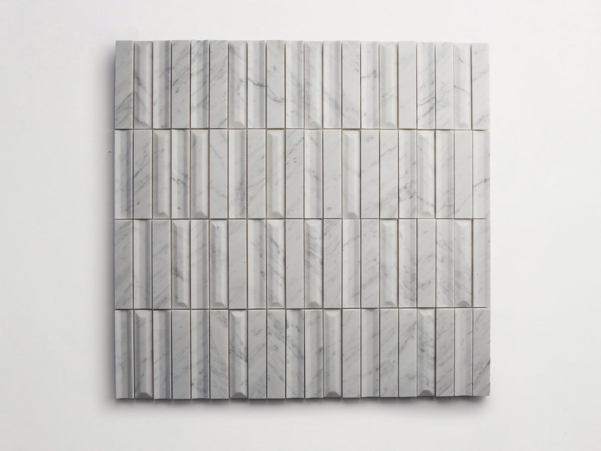 A grid of rectangular white marble tiles with gray veining arranged evenly on a white background.
