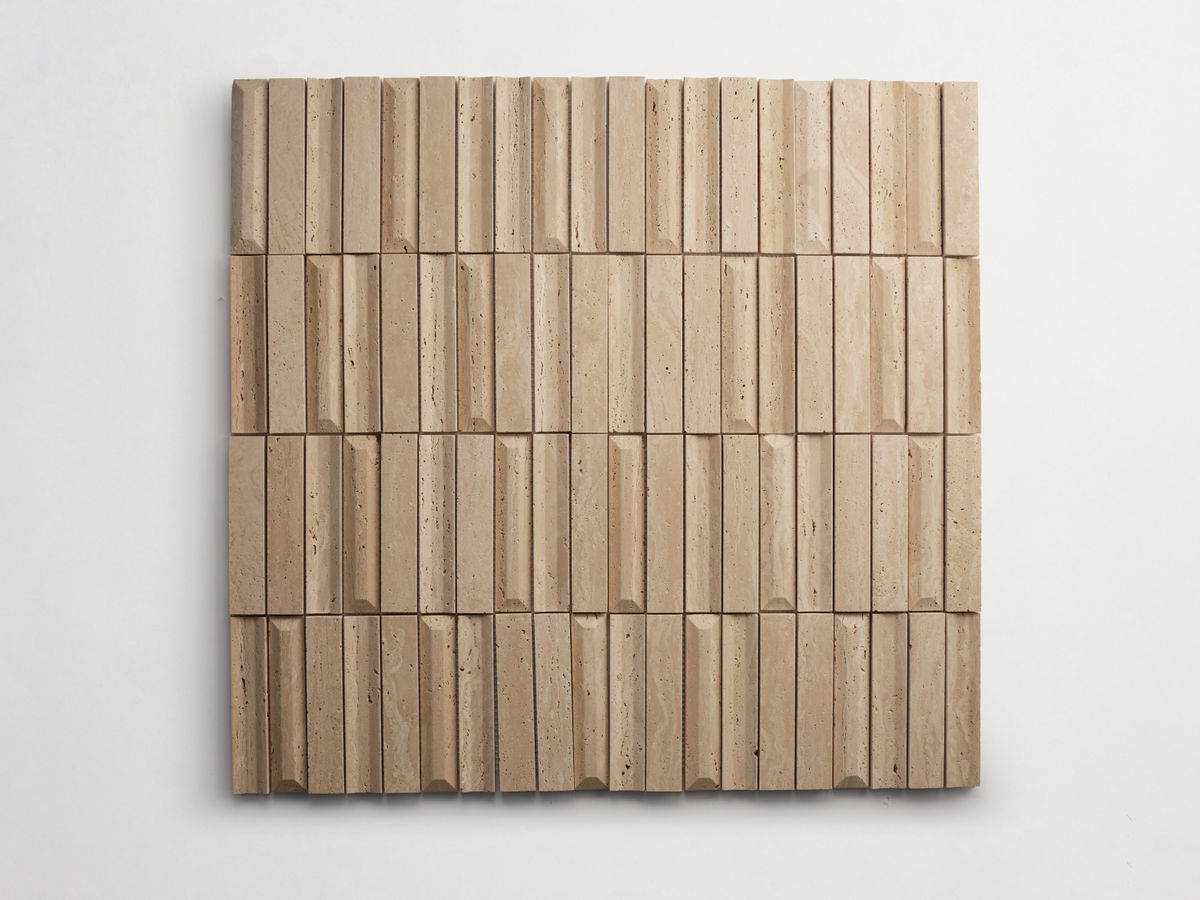 Square wall art made of beige stone tiles arranged in a grid, each tile featuring vertical grooves and textured surfaces.