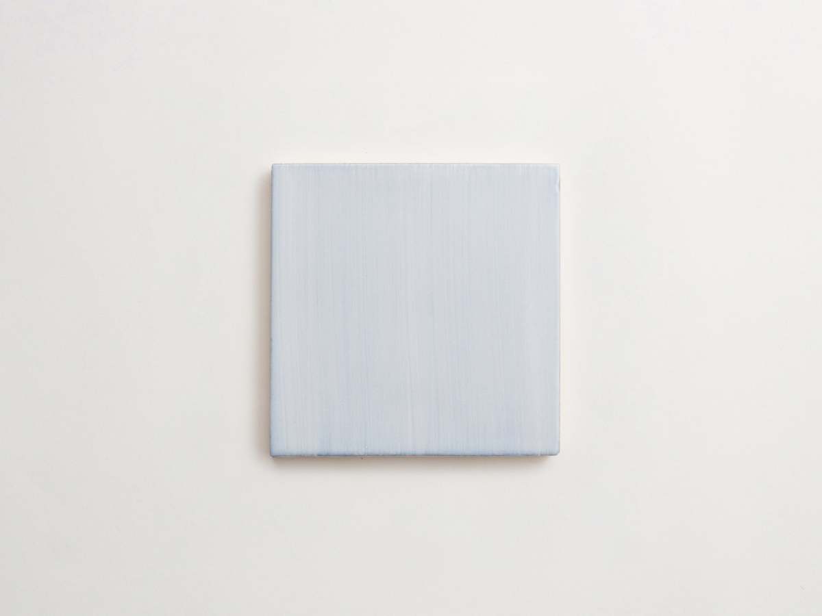 Painted light blue majolica delft square backsplash tile.