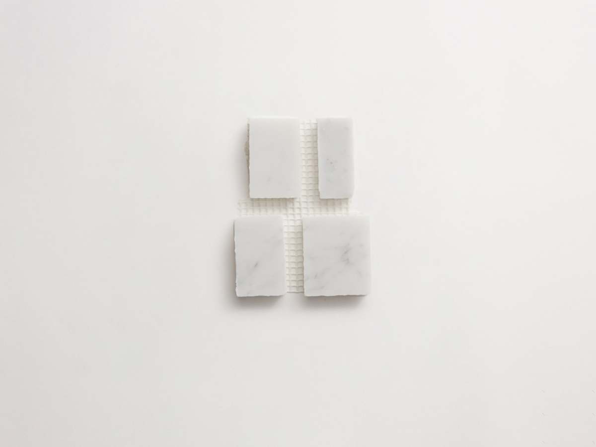 Carrara marble rough cut mosaic tile large joint.