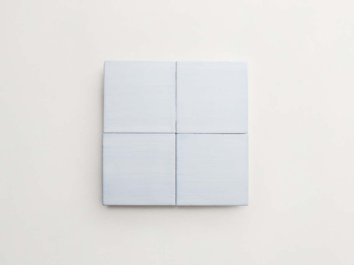 Painted light blue majolica delft square backsplash tile.