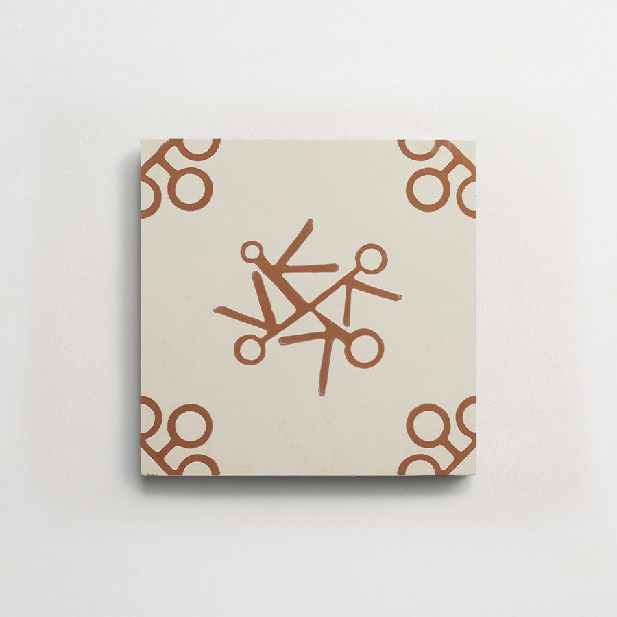 Square ceramic tile with a beige background featuring a brown scissors motif in the center and at each corner.
