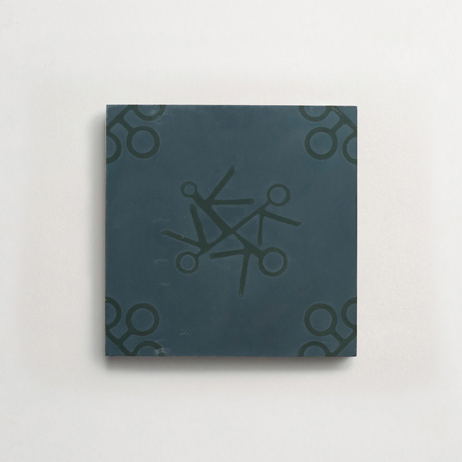 A square, dark green tile with a pattern of scissors arranged in a circular formation in the center and in each corner, on a plain light background.