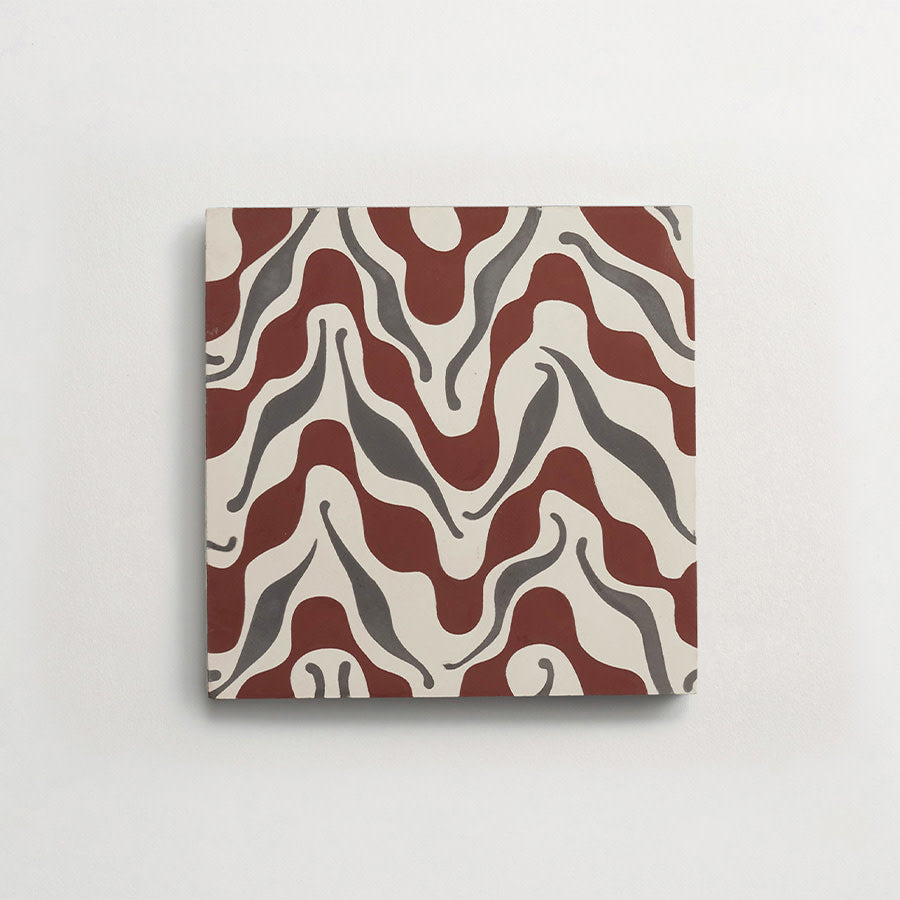 A square ceramic tile with a wavy red and gray abstract pattern on a white background, displayed against a plain white wall.