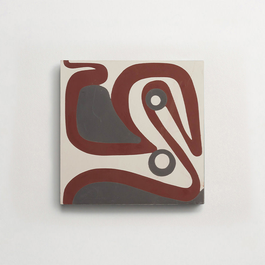 A square tile with abstract, curving maroon and gray lines and circles on an off-white background, mounted on a plain white wall.