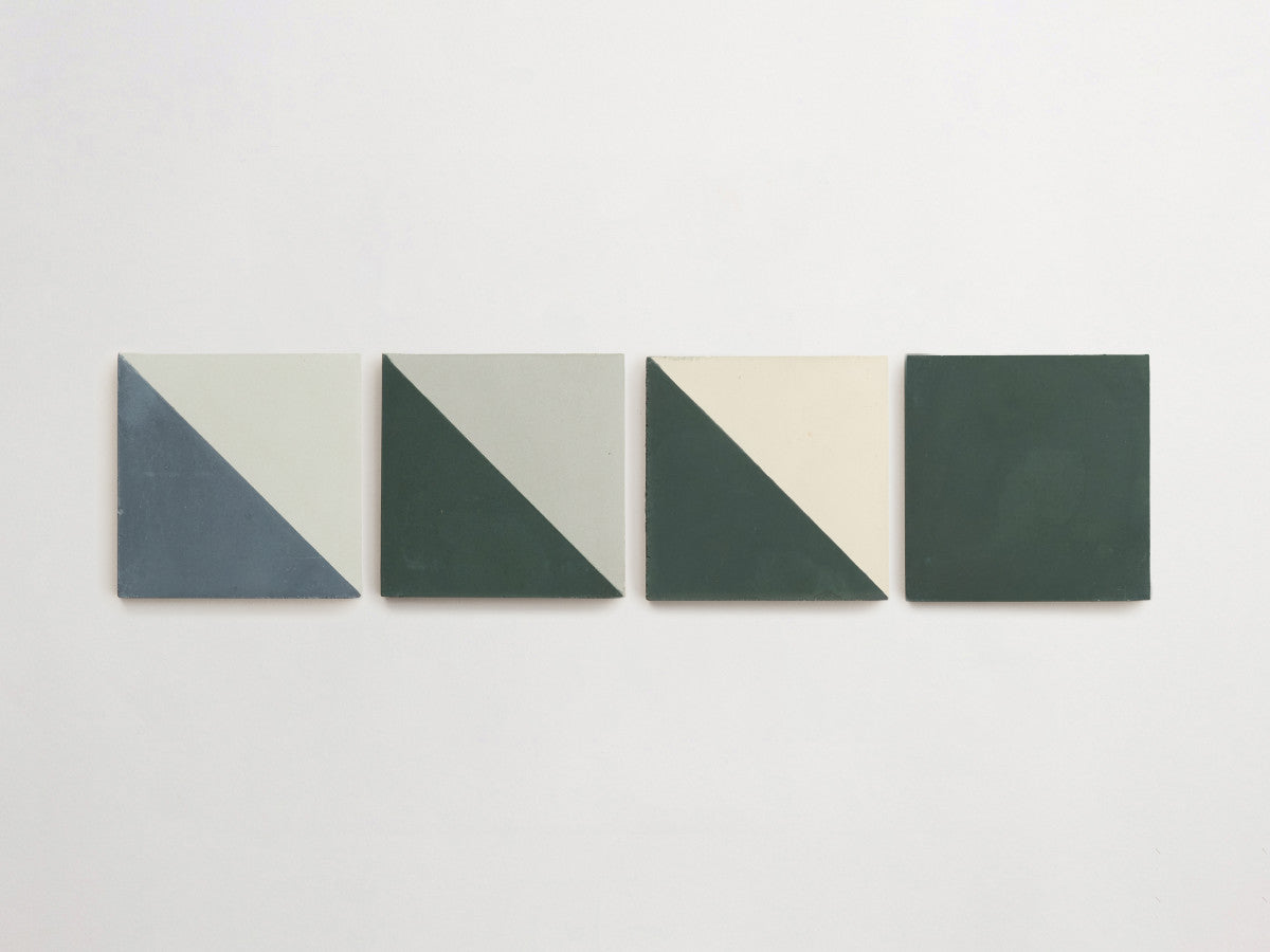 Four square tiles arranged in a row, each divided diagonally with two contrasting colors, transitioning from light to dark from left to right.