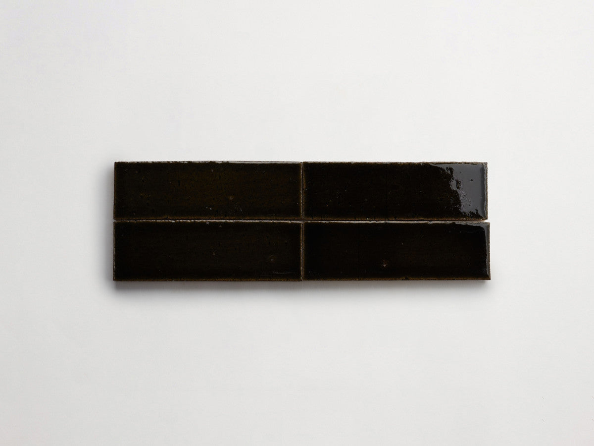 Four rectangular black ceramic tiles are arranged in a horizontal row on a plain white background.