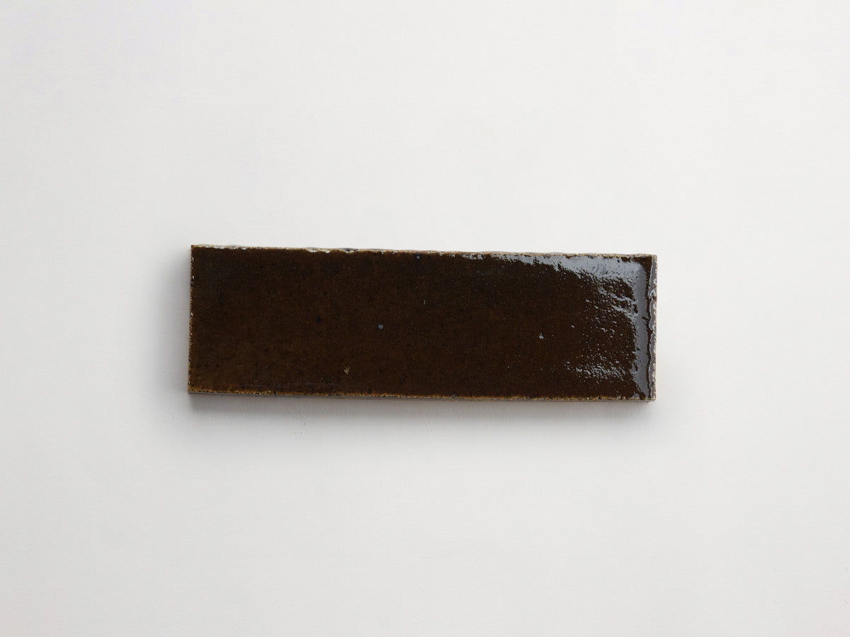 A rectangular slab with a smooth, glossy, dark brown surface placed on a plain white background.
