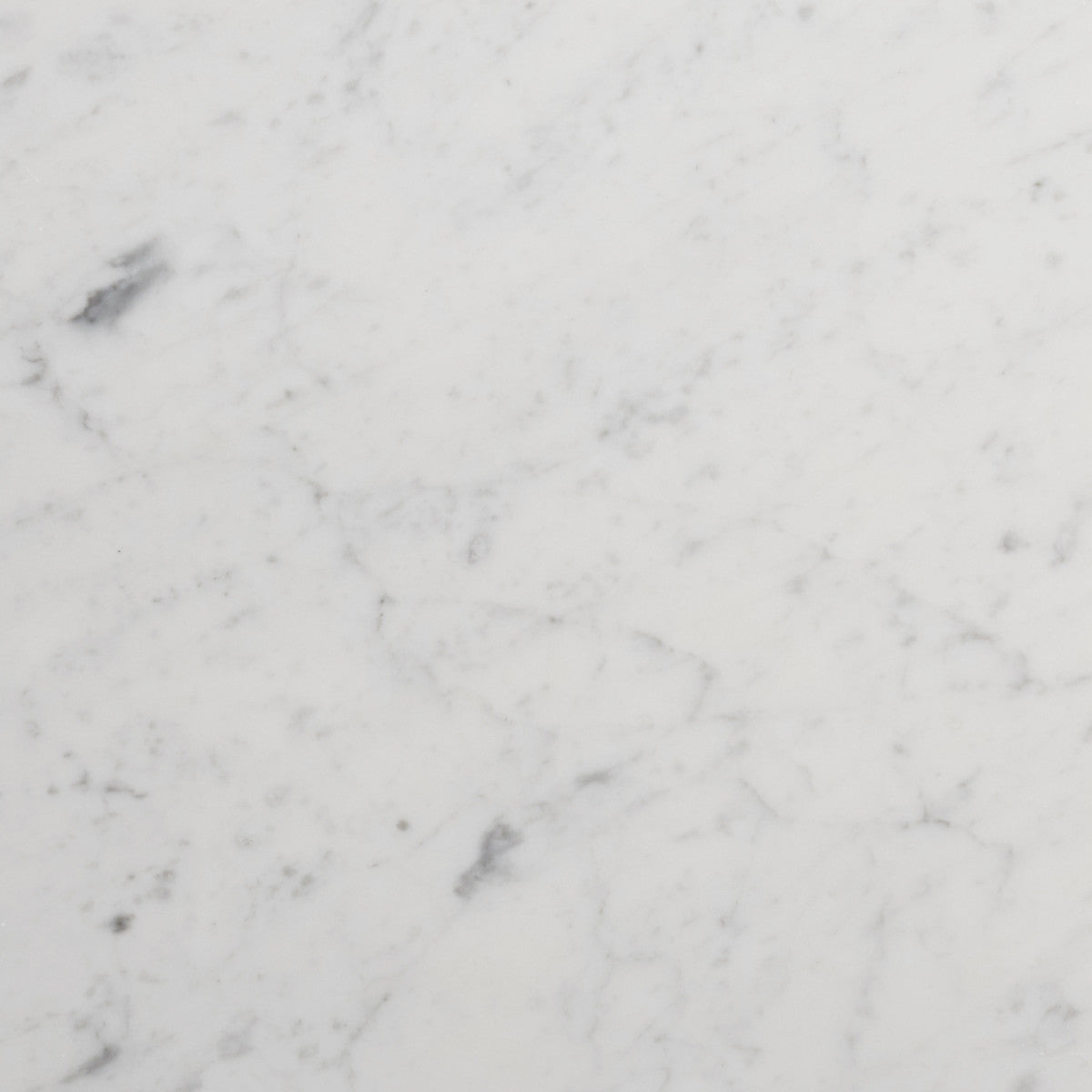 White marble surface with subtle gray veining and small dark spots, showcasing a smooth, polished texture.