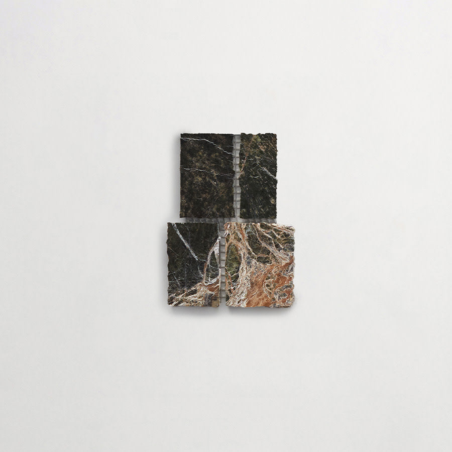 Four square, textured tiles with various dark and light marble patterns are arranged in a grid on a plain white background.