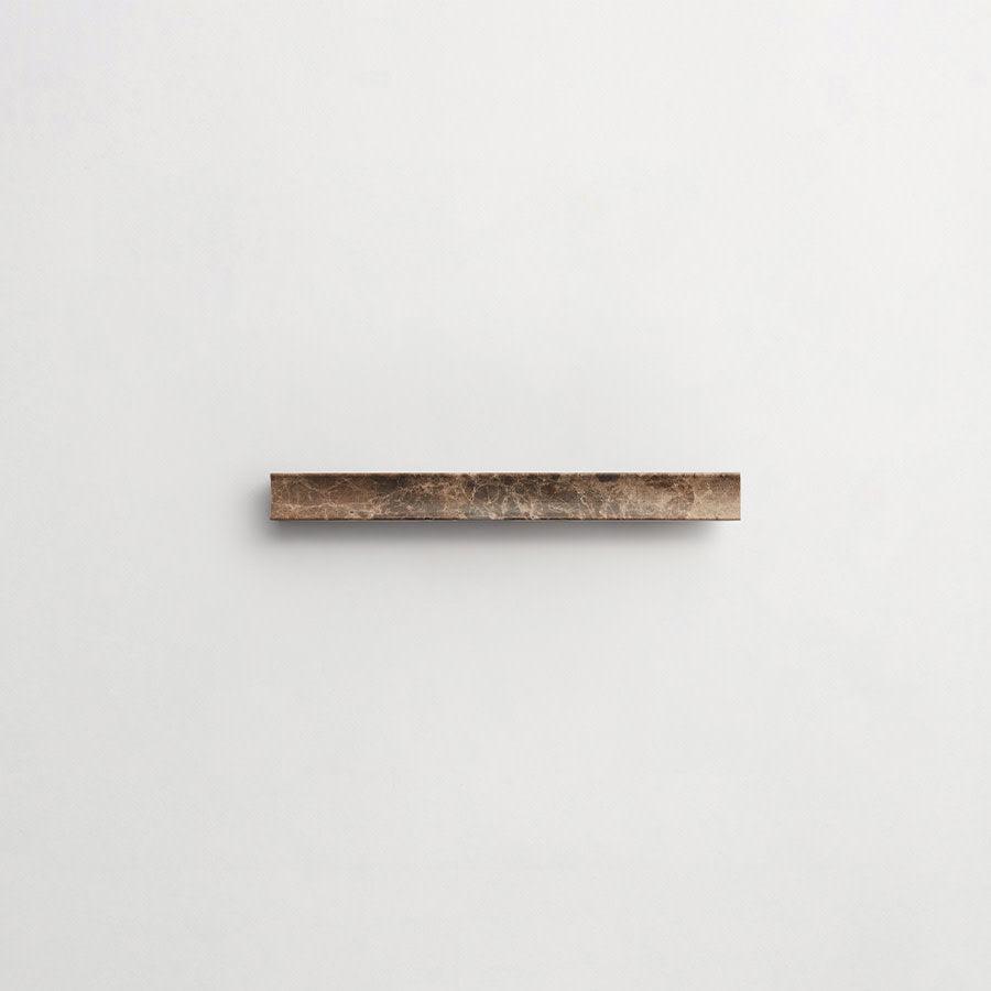 A single narrow, rectangular piece of brown stone mounted horizontally on a plain white wall.