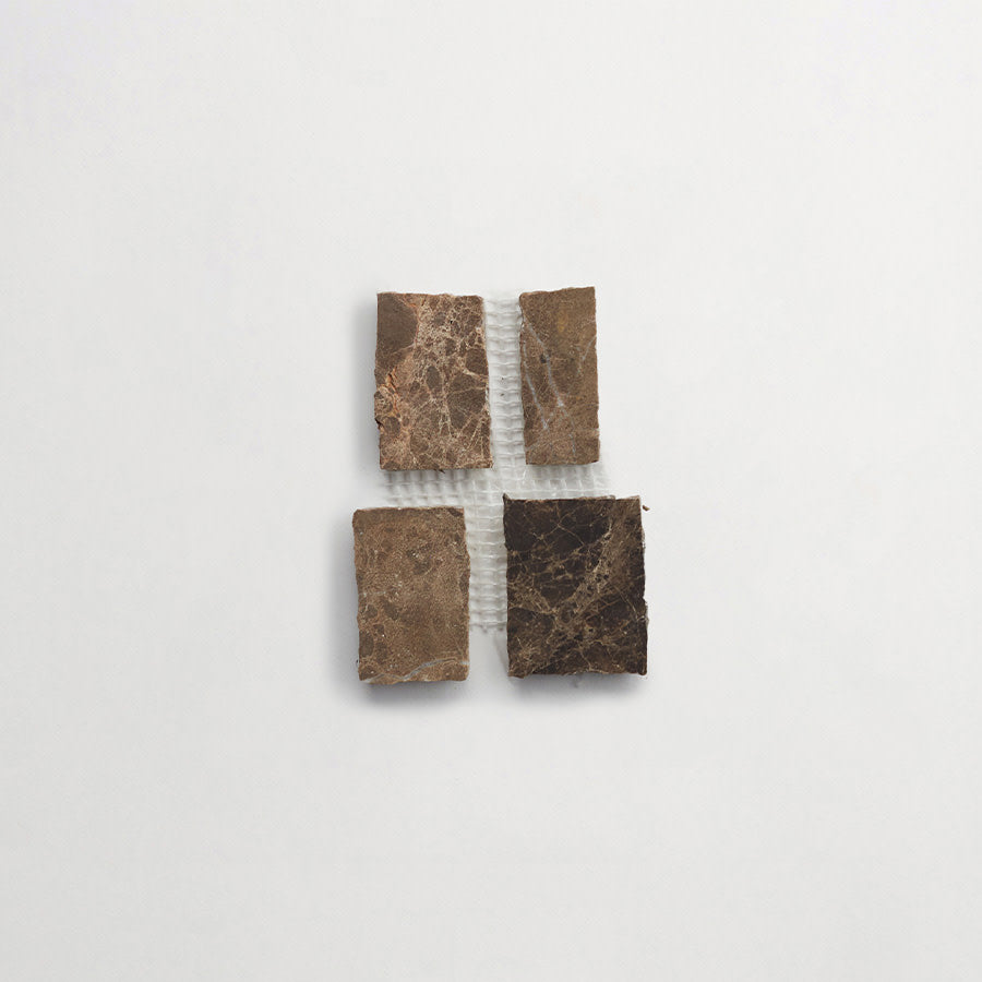 Four rectangular brown marble tiles are arranged in a square pattern with a small gap in the center on a plain white background.