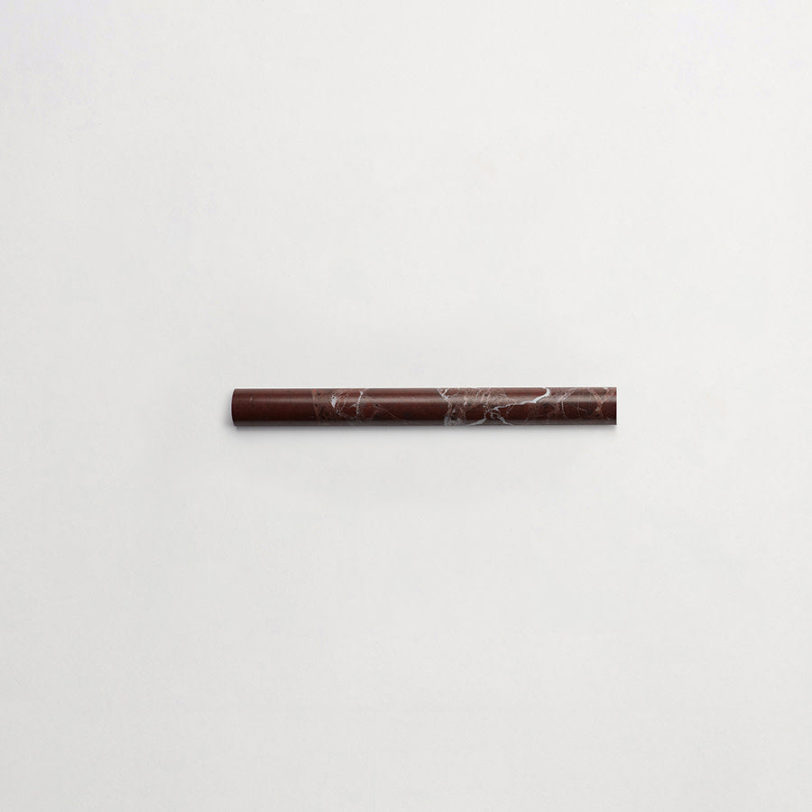 A single brown marble cylinder with white veining lies horizontally on a plain white background.