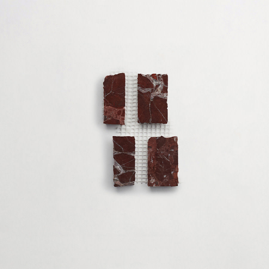Four rectangular pieces of dark red marble with white veining are arranged on a white mesh grid against a plain white background.