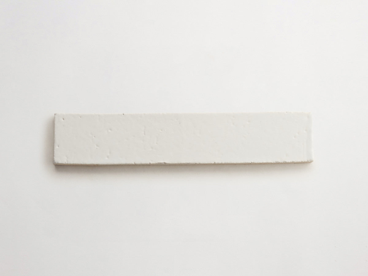 A rectangular, flat, white ceramic tile is placed on a plain white background.