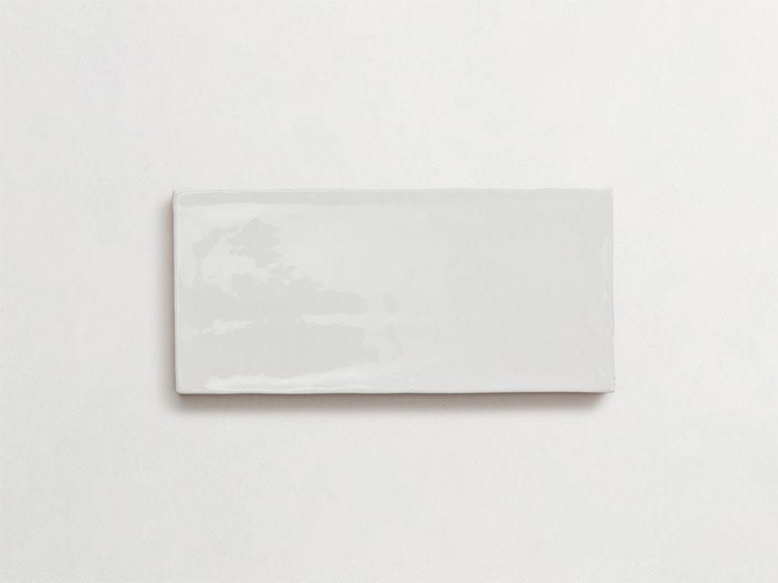 Rectangular white ceramic tile with a glossy finish placed on a plain white background.