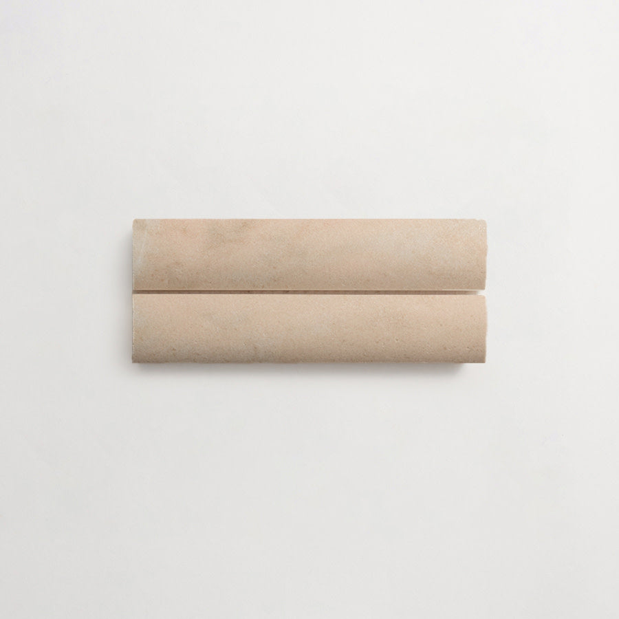 Two beige cylindrical sticks placed parallel to each other on a plain white background.