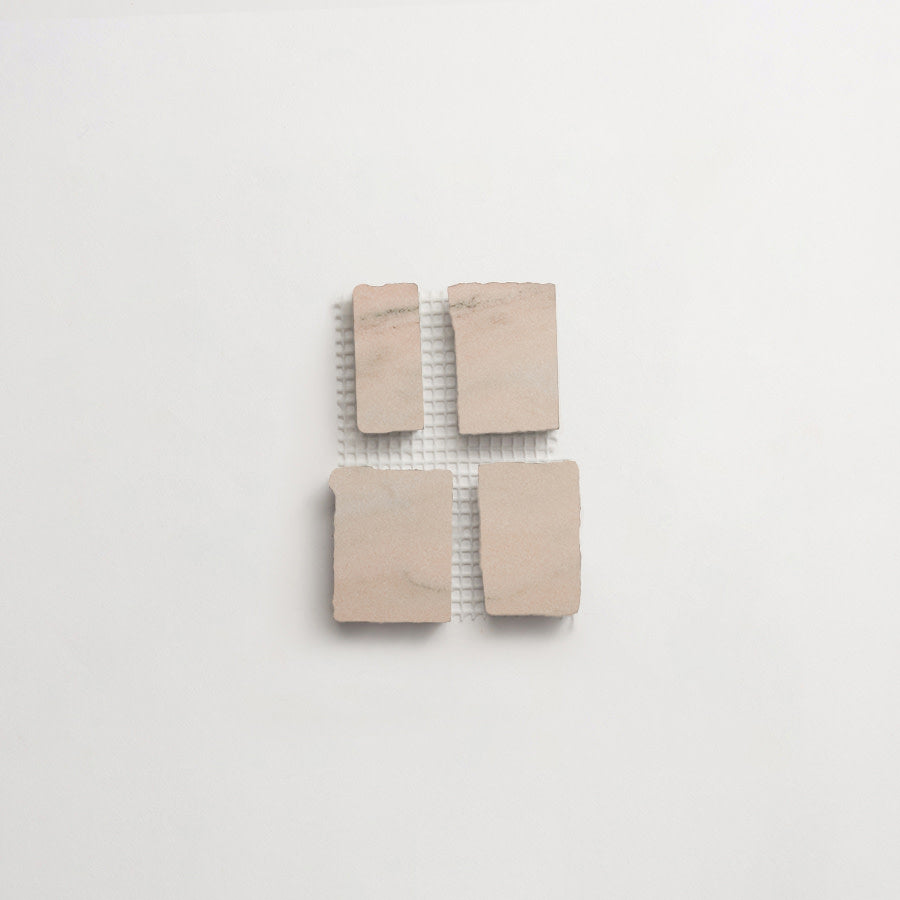 Four rectangular beige stone tiles arranged in a grid on top of a white mesh backing, placed on a plain white background.