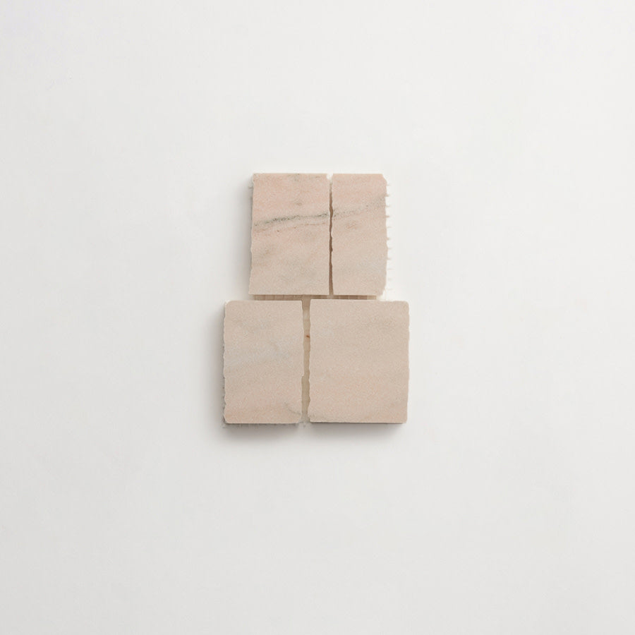 Four square beige tiles arranged in a two-by-two grid on a plain white background. The tiles have subtle natural variations in color and texture.