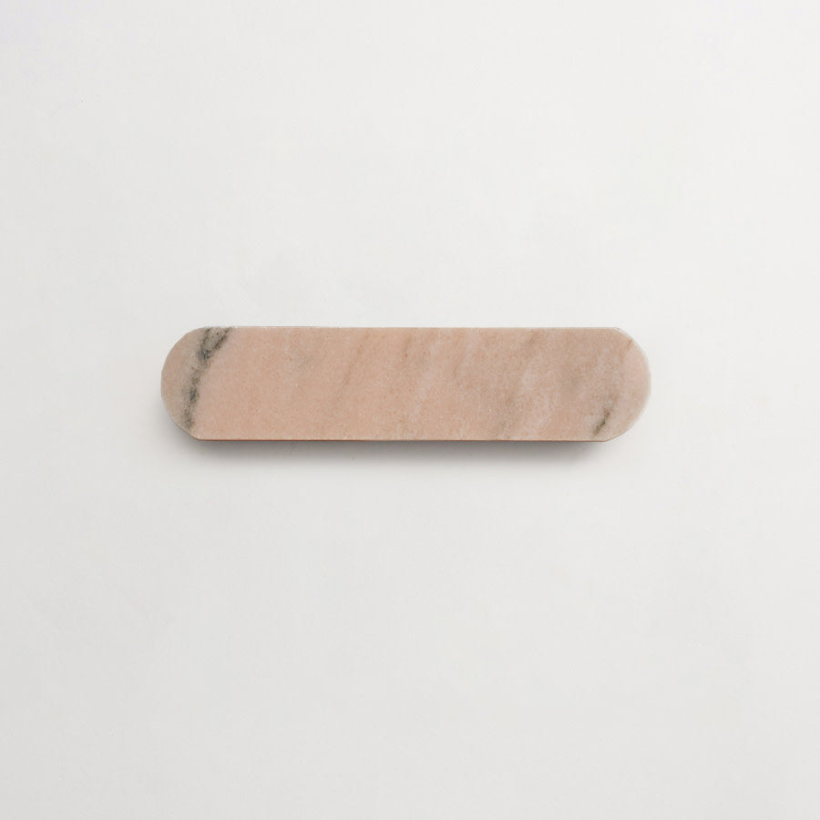 A rectangular, rounded-edge slab of light pink stone with subtle gray veining, placed on a plain white background.