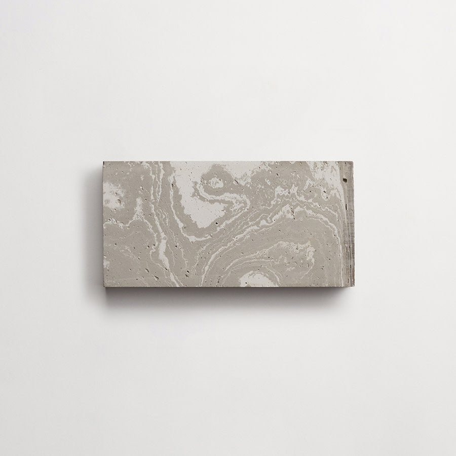 A rectangular slab of marbled gray concrete mounted on a plain white wall.