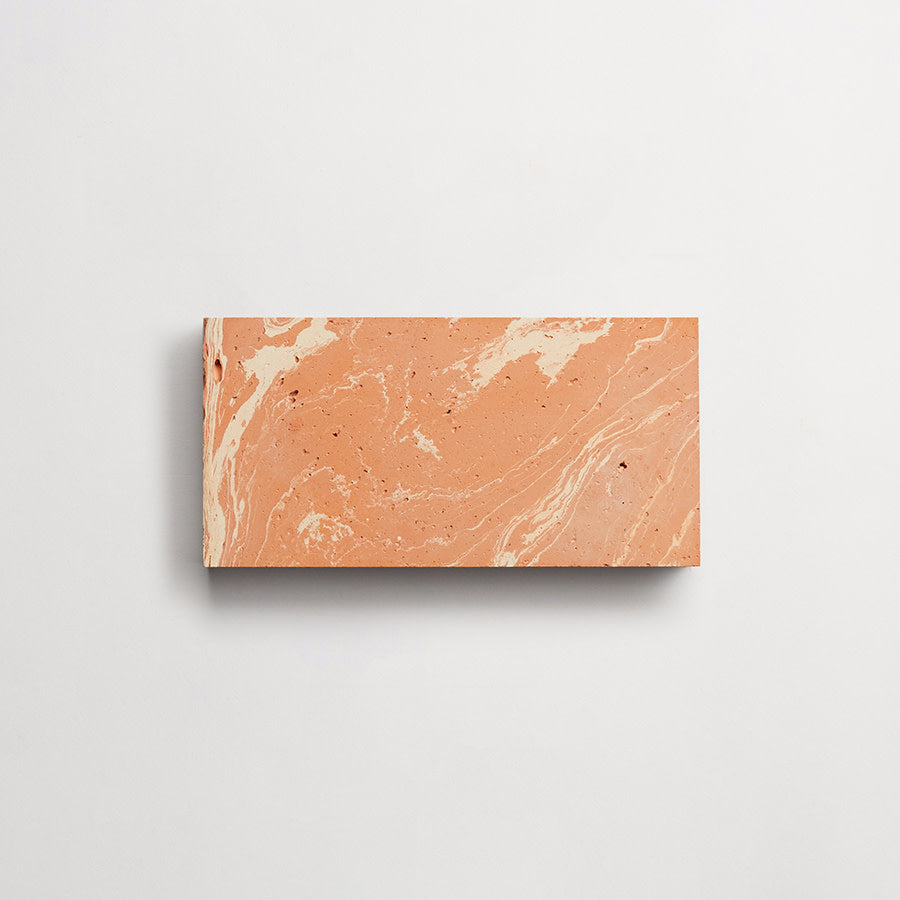 Rectangular block of terracotta-colored material with cream-colored marbled patterns, displayed against a plain white background.