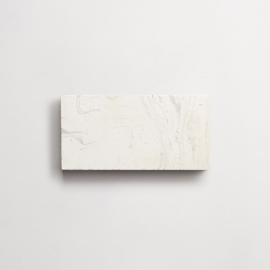 Rectangular white tile with subtle gray veining and small speckles, displayed against a plain white background.