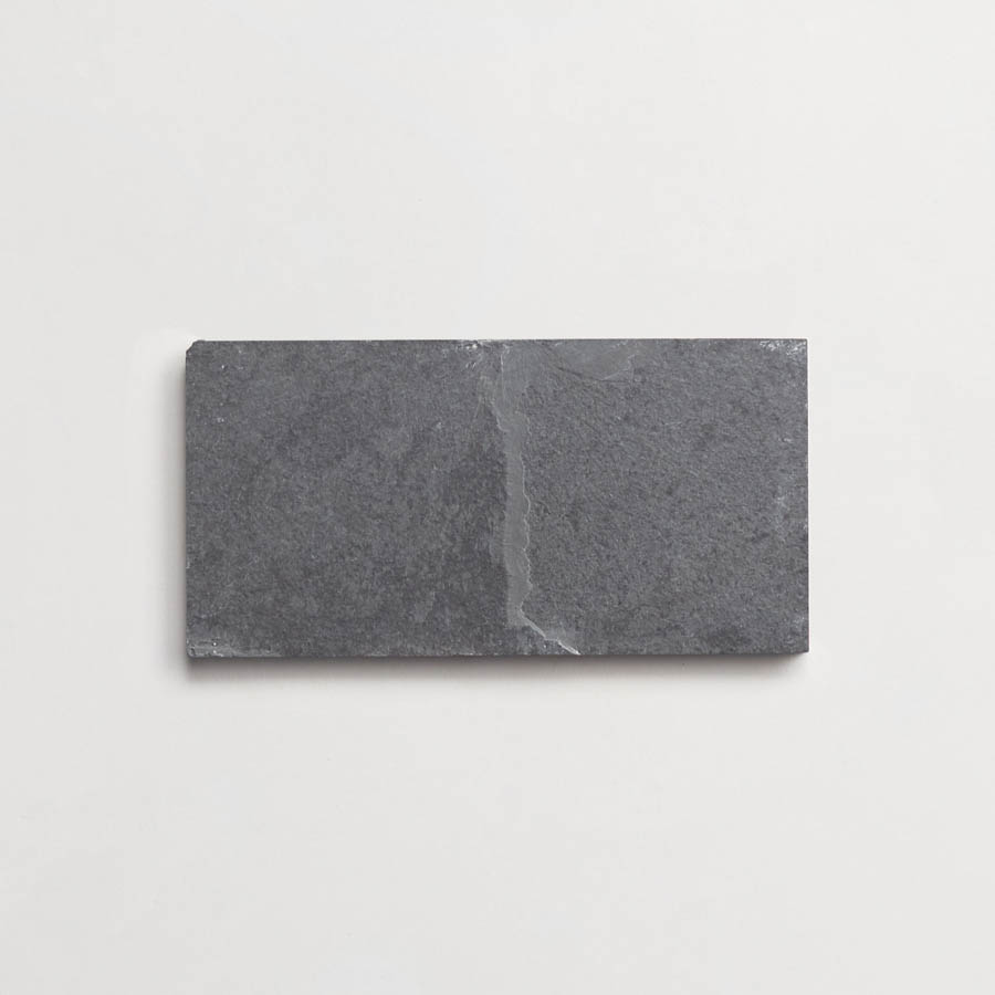 A rectangular, dark gray slate tile is placed on a plain white background.