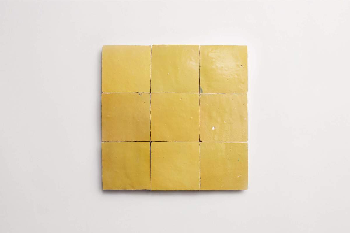Nine square yellow tiles arranged in a three-by-three grid on a plain white background.