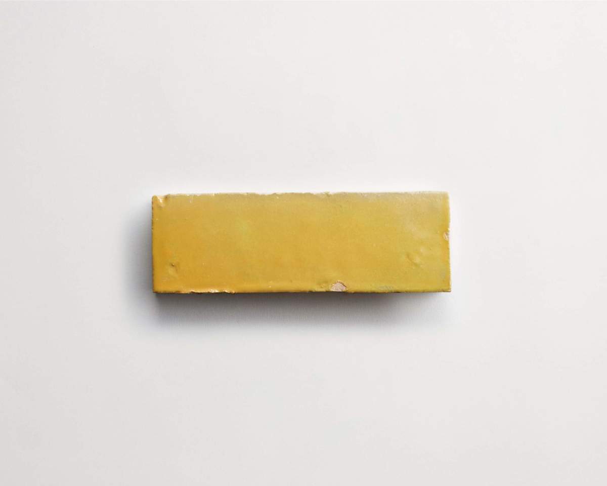 A rectangular block of yellow cheese on a plain white background.