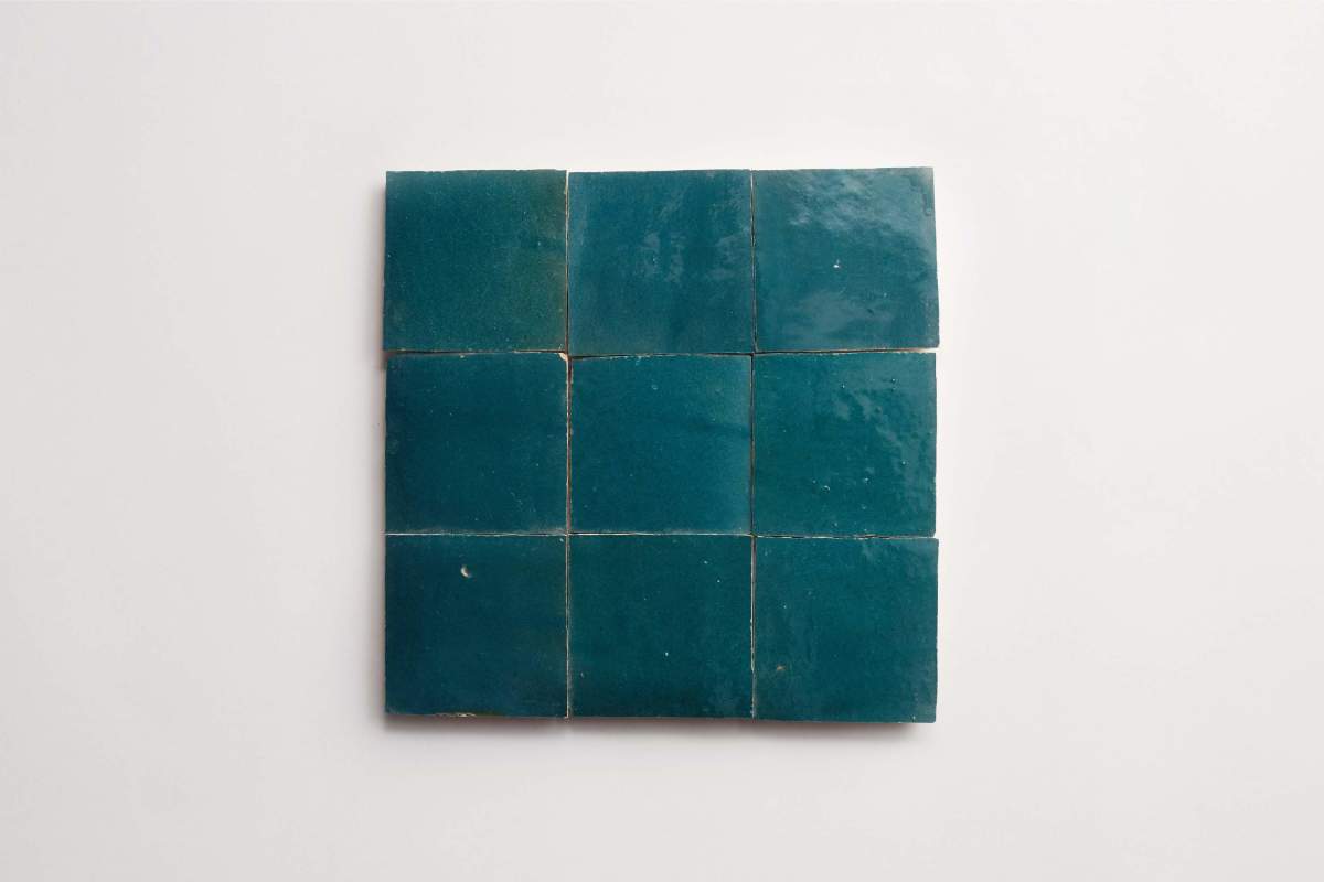 Nine square teal ceramic tiles are arranged in a three-by-three grid on a plain white background.