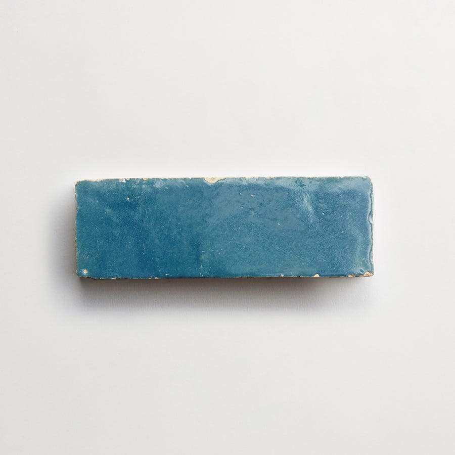 A rectangular blue ceramic tile with a glossy finish, displayed on a plain white background.