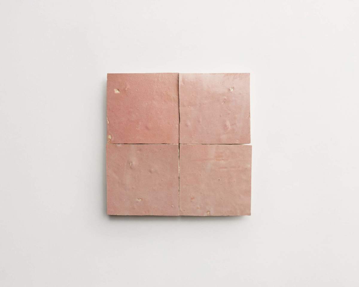 Four square, light pink ceramic tiles arranged in a 2x2 grid on a plain white background.