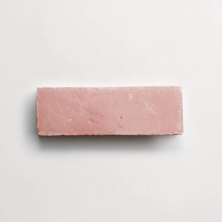 A single rectangular pink brick is placed on a plain white background.