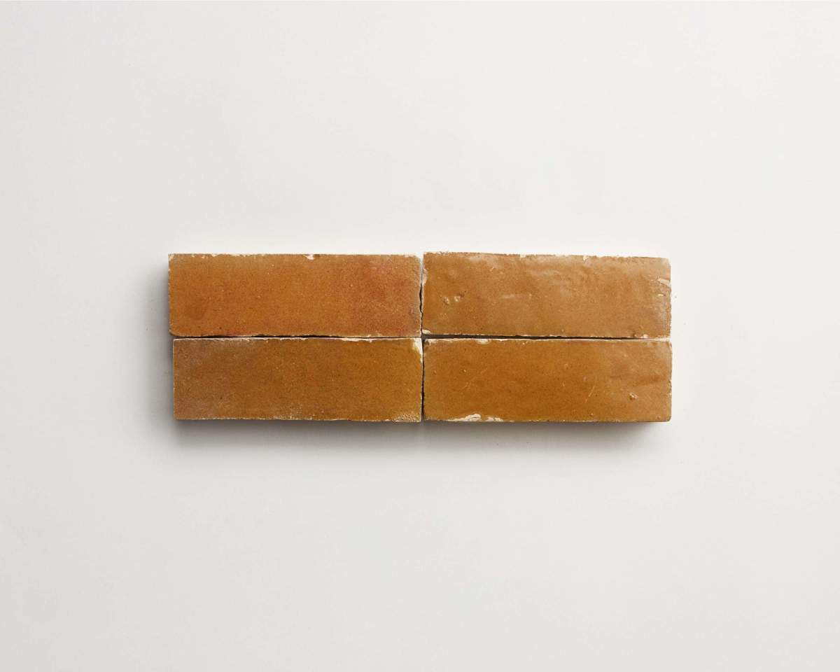 Four rectangular brown bricks are arranged in two rows on a plain white background.