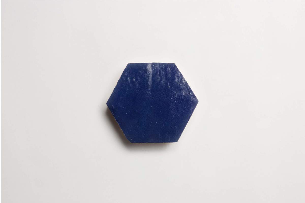 A single dark blue hexagonal tile is placed on a plain white background.