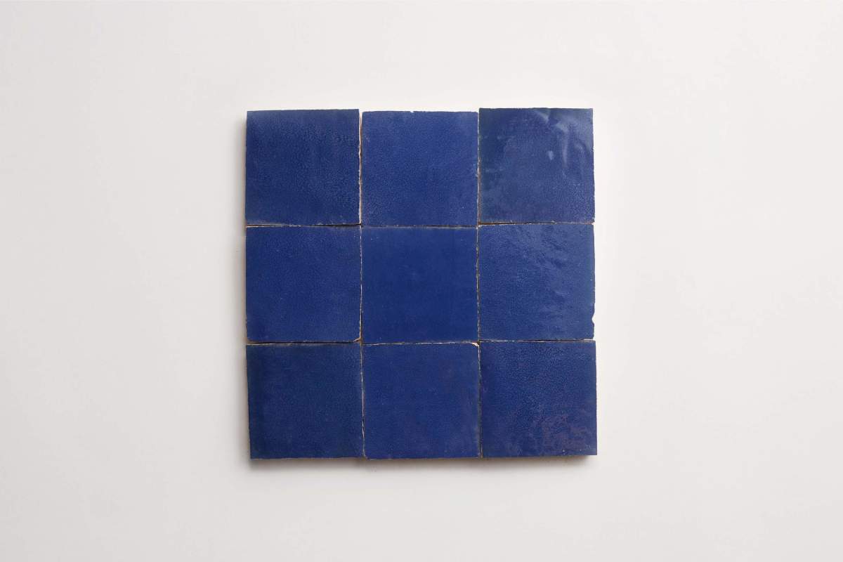 Nine square, glossy blue tiles arranged in a 3x3 grid against a plain white background.
