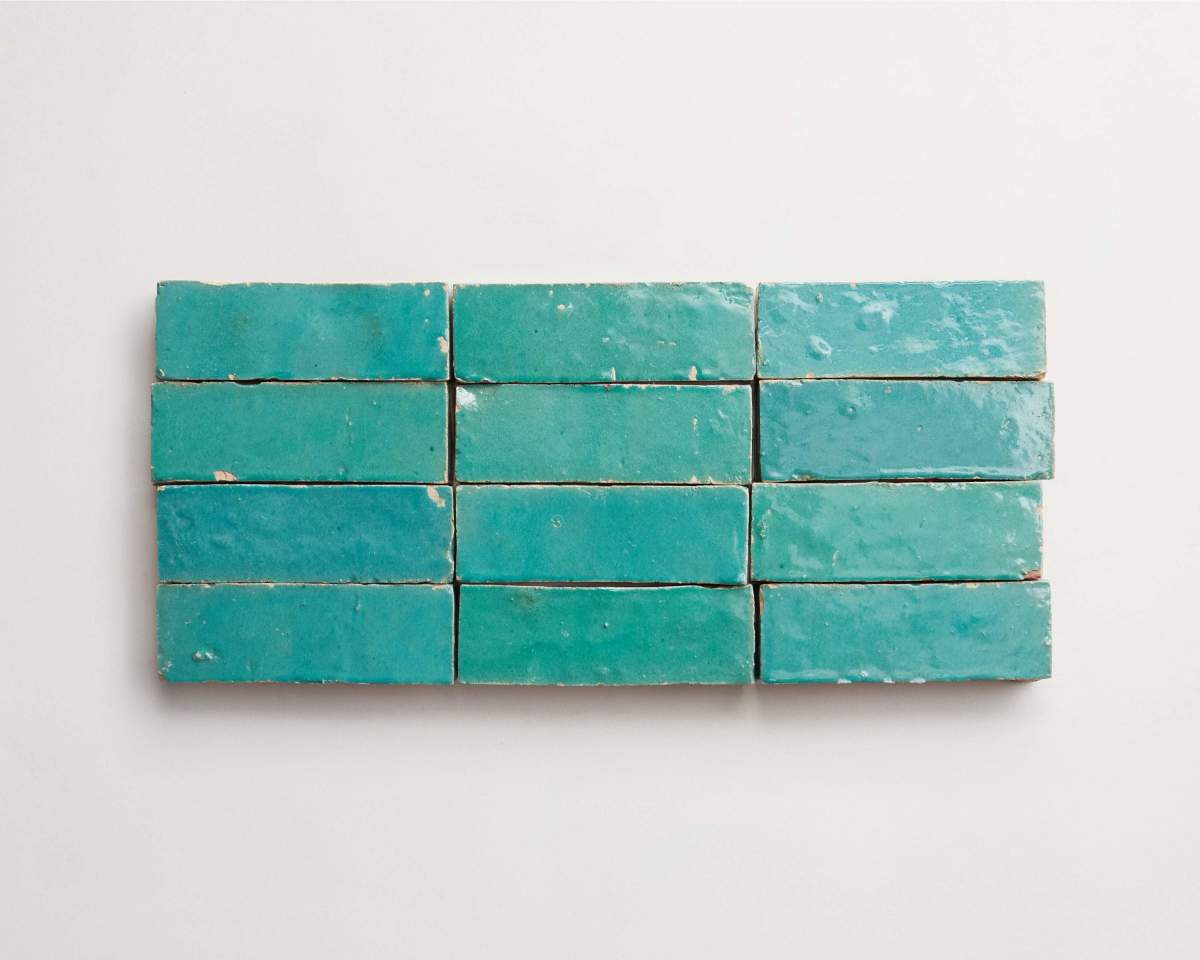 Rectangular teal ceramic tiles arranged in three rows on a plain white background.