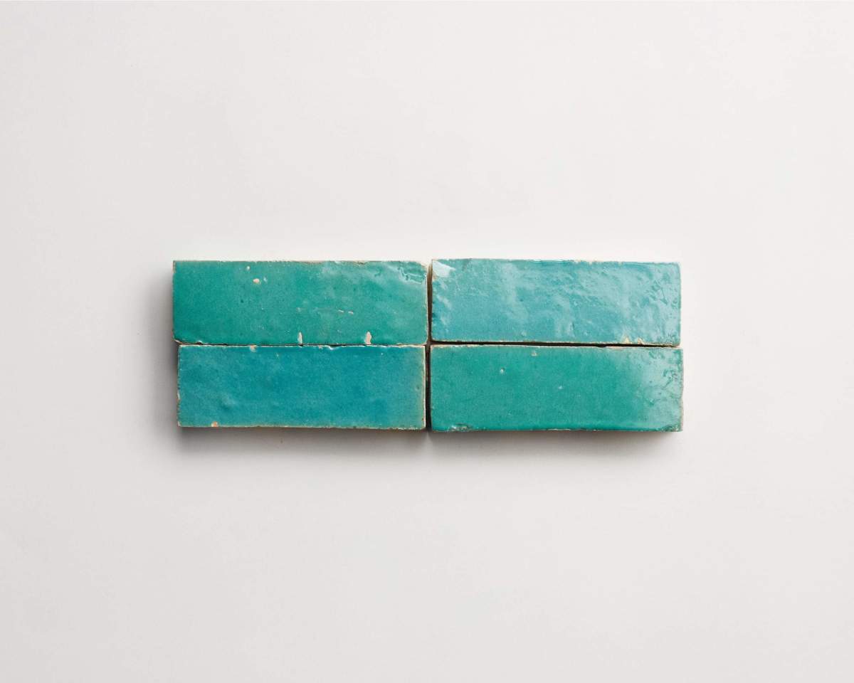 Four rectangular teal ceramic tiles are arranged in two rows of two on a plain white background.