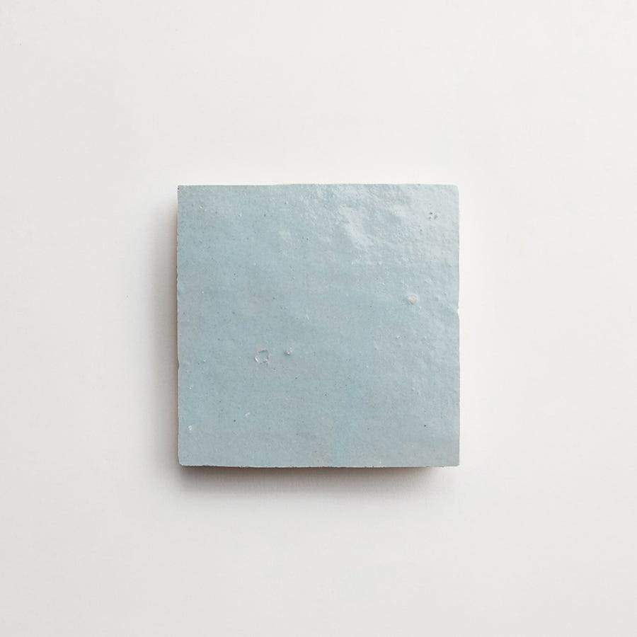 A single light blue square tile is centered on a plain white background.