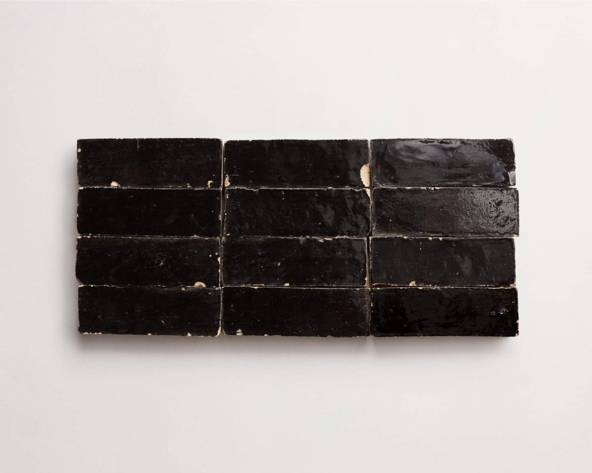 Twelve rectangular, glossy black tiles arranged in three rows of four on a plain white background.