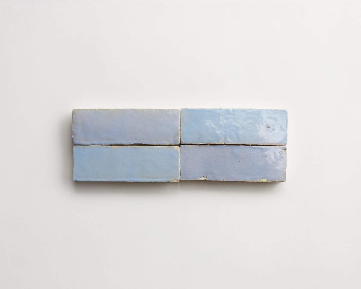 Four rectangular, light blue glazed tiles arranged in two rows on a plain white background.