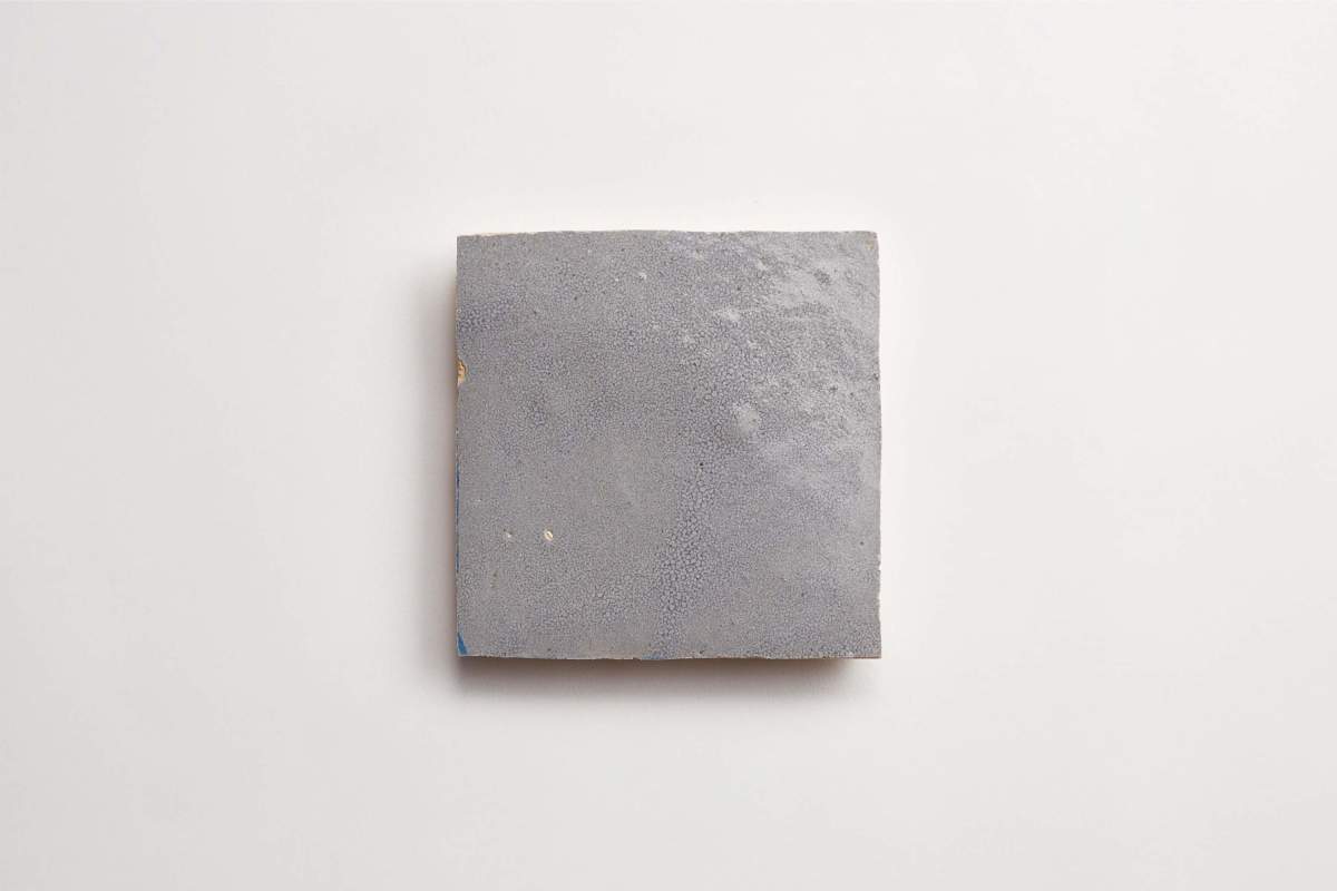 A single gray square tile with a slightly textured surface is centered on a plain white background.